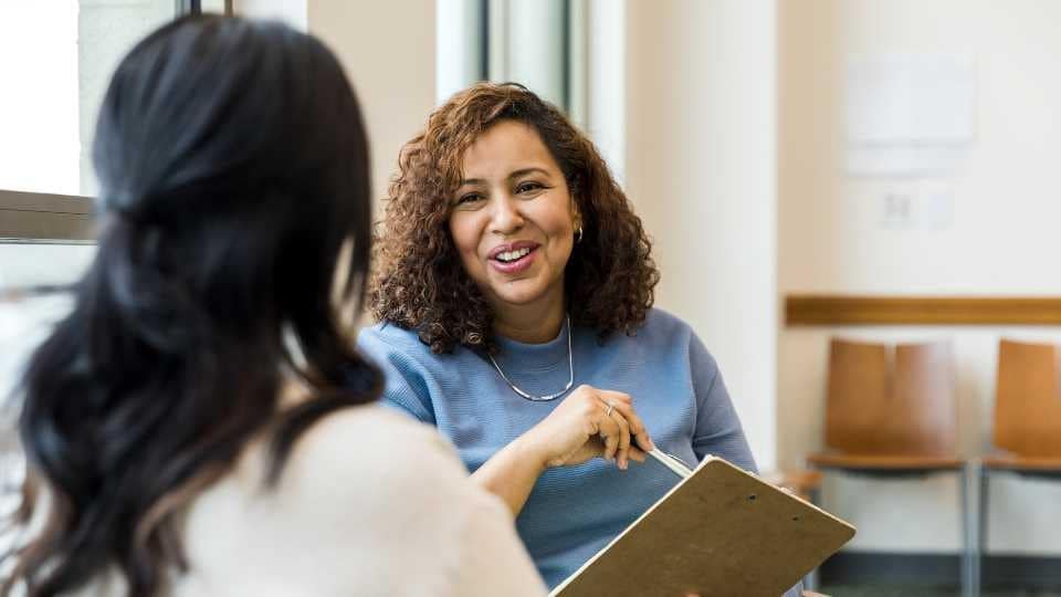 Two women discussing things at work.